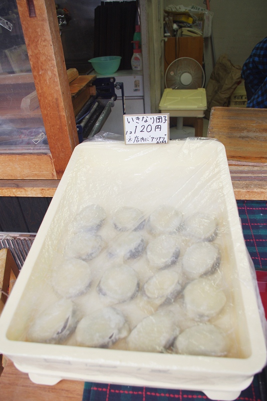 It is Ikinari-dango(dumpling)-Karatsu's local traditional sweets. There are 16 dumplings in a white container. The name "Ikinari Dango" and "120 yen per dumpling" are written on the plate.