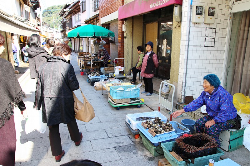 At the morning market in Yobuko, local fishermen and farmers sell fresh seafood and vegetables on the street.