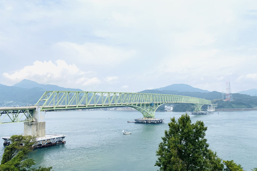 周防大島と本州本土を結ぶ大島大橋です。トラス橋でトラスは黄緑色です。橋の下を小さな船が通っています。