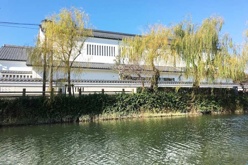 This is the view from a punting boat in Yanagawa. The white walls of the buildings are called Namako-kabe (Namako walls). Willow trees are lined up along the moat.
