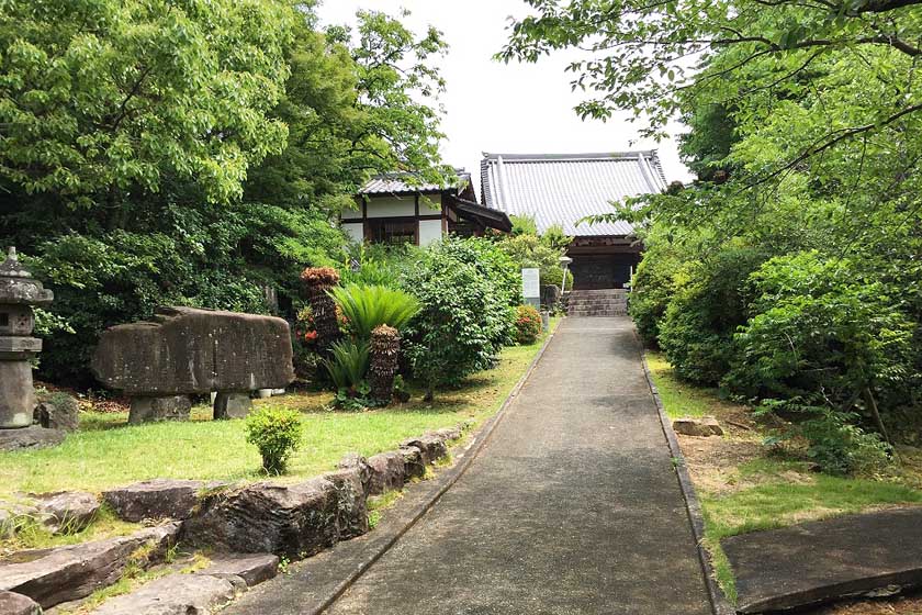 The main hall of Eifukuji Temple is located at the end of the approach surrounded by trees.