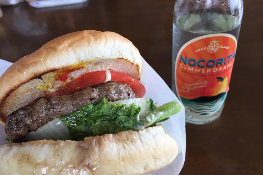 The beverage NOCORITA is placed next to the Noco Burger hamburger.