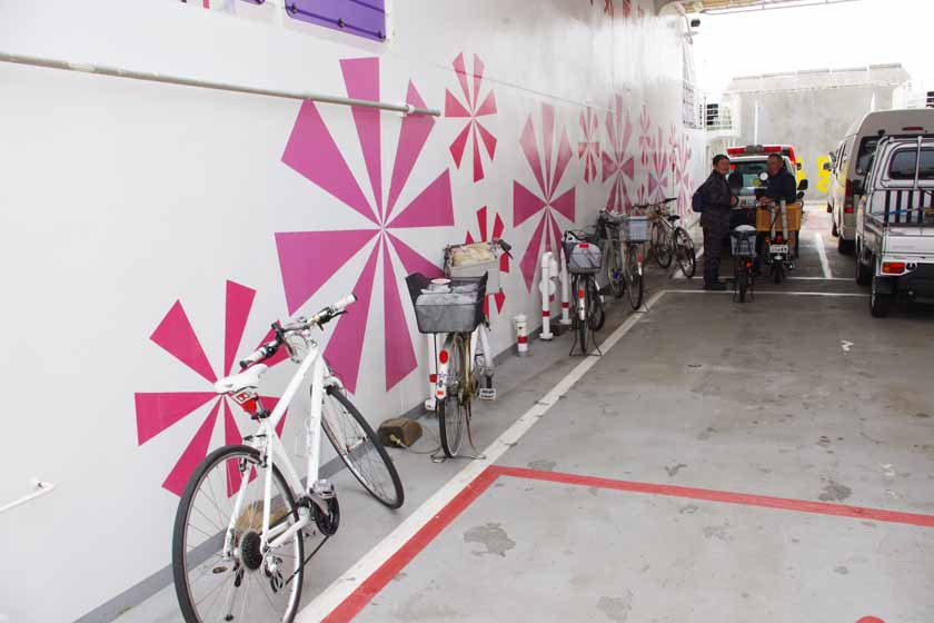 Bicycles and cars are parked on the ferry.